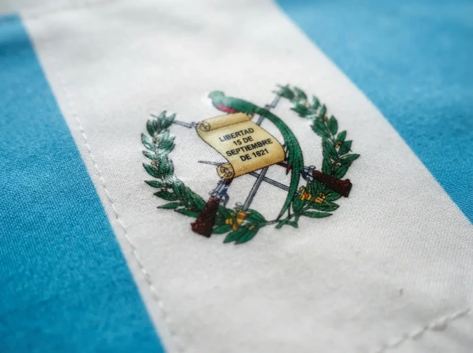 Vista cercana de bandera de Guatemala fabricada con impresión DTF textil, destacando la nitidez de los detalles, la suavidad del tiraje y la durabilidad de la tinta sobre la tela.